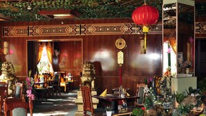 A traditional interior with wooden walls, a central lion statue, and a red lantern. - Hotel Europäischer Hof (Elsterwerda)