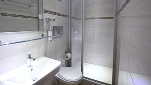 A modern bathroom with a glass shower enclosure, a white sink, and a toilet. - Hotel Europäischer Hof (Elsterwerda)