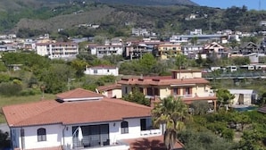A two-story house with a swimming pool and a mountain in the background. - Villa Nunzia (Ercolano)