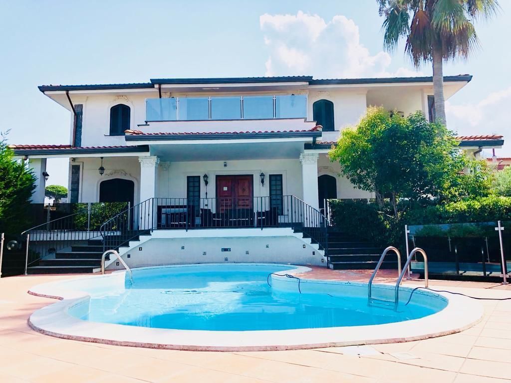 A two-story building with a swimming pool in front.