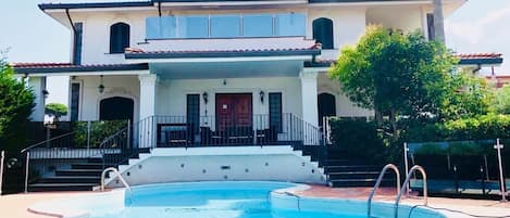 Un edificio de dos plantas con piscina delantera.