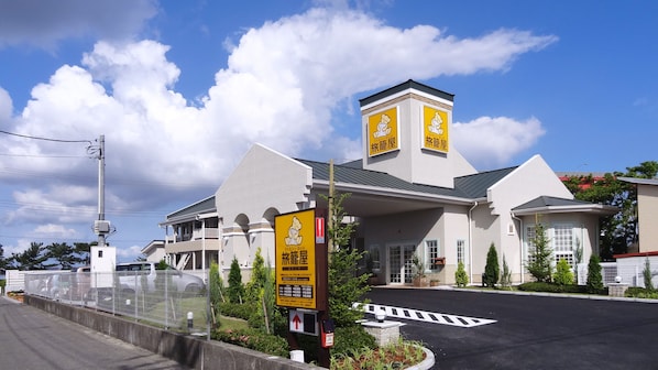 A hotel with a prominent tower, multiple balconies, and a clear sky. - Family Lodge Hatagoya Kisarazukou (Kisarazu)