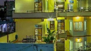 Um edifício residencial de vários andares, com varandas e entrada visível.