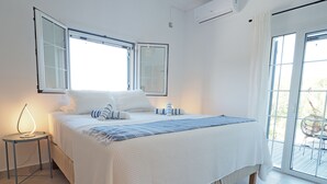 Ein Schlafzimmer mit einem großen Bett, einem Nachttisch und einem Fenster.