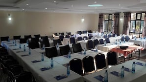 A conference room with tables, chairs, and water bottles. - Twiggs Hotel (Bomet)