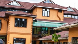 A two-story building with a flat roof and a green awning over the entrance. - Twiggs Hotel (Bomet)