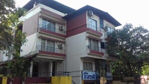 A multi-story building with balconies and air conditioning units. - Hotel Rajdhani (Mawal)