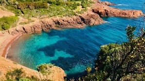 A coastal landscape with rocky cliffs, clear turquoise waters, and greenery. - Exceptional Location - Air-Conditioned Studio for 2-3 People Near Beach & Shops (Saint-Raphaël)