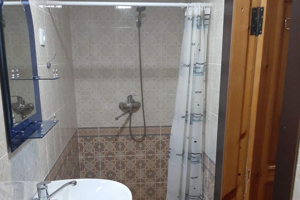 Chambre Standard double | Commodités de la salle de bain | Douche, douche cascade, articles de toilette (gratuits), pantoufles