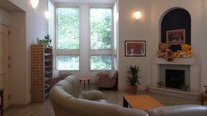 Een woonkamer met een open haard, twee banken, een salontafel en een boekenkast.