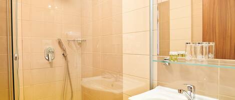 A modern bathroom with a glass shower enclosure, a built-in sink, and a mirror above the sink.