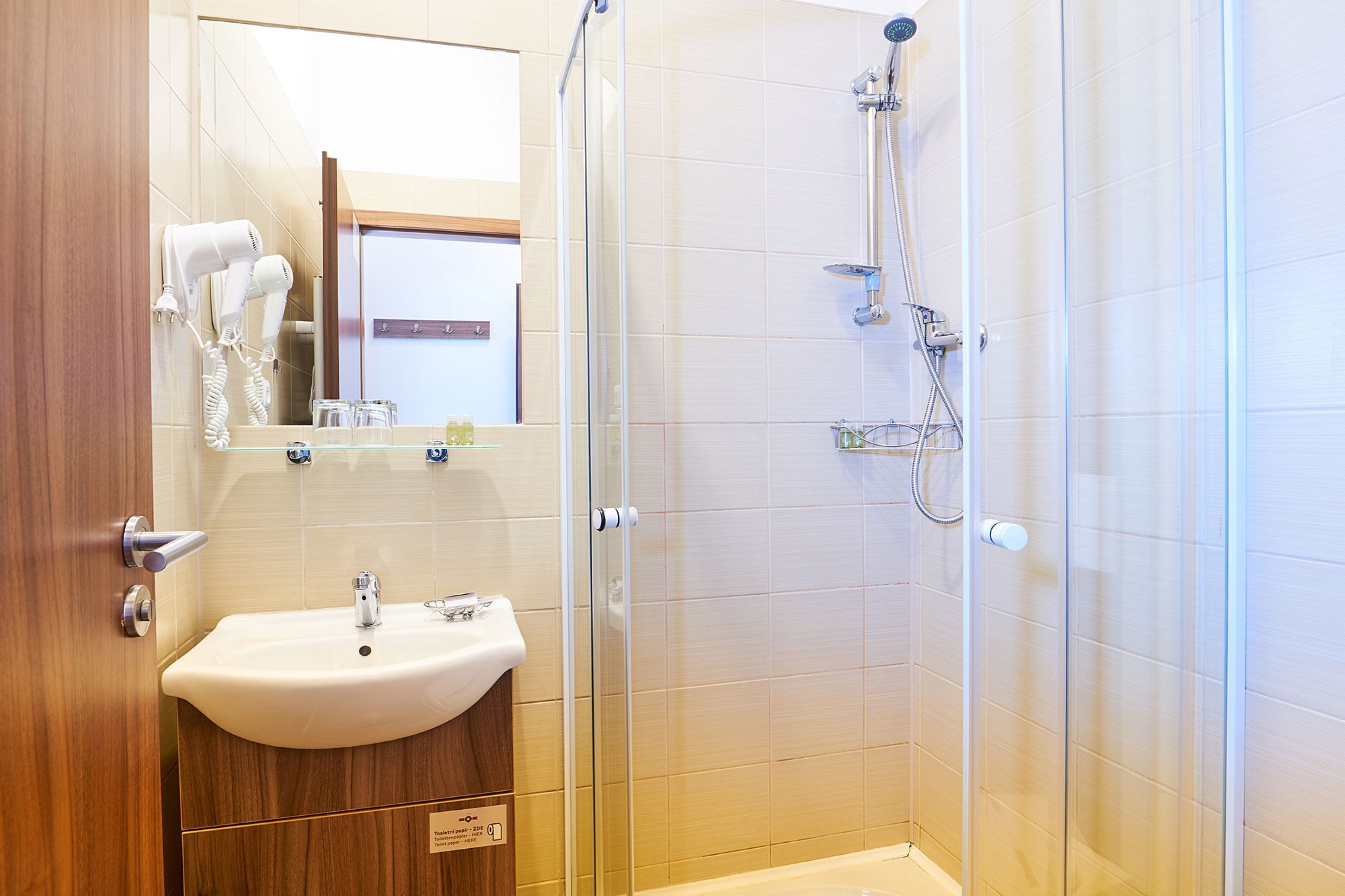 A modern bathroom with a sink, mirror, and shower.