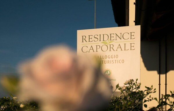 Señal de 'Residence Caporale' con un logotipo que indica un lugar apto para turistas.
