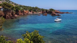 Une zone côtière caractérisée par un terrain rocheux et des eaux d’un bleu limpide.