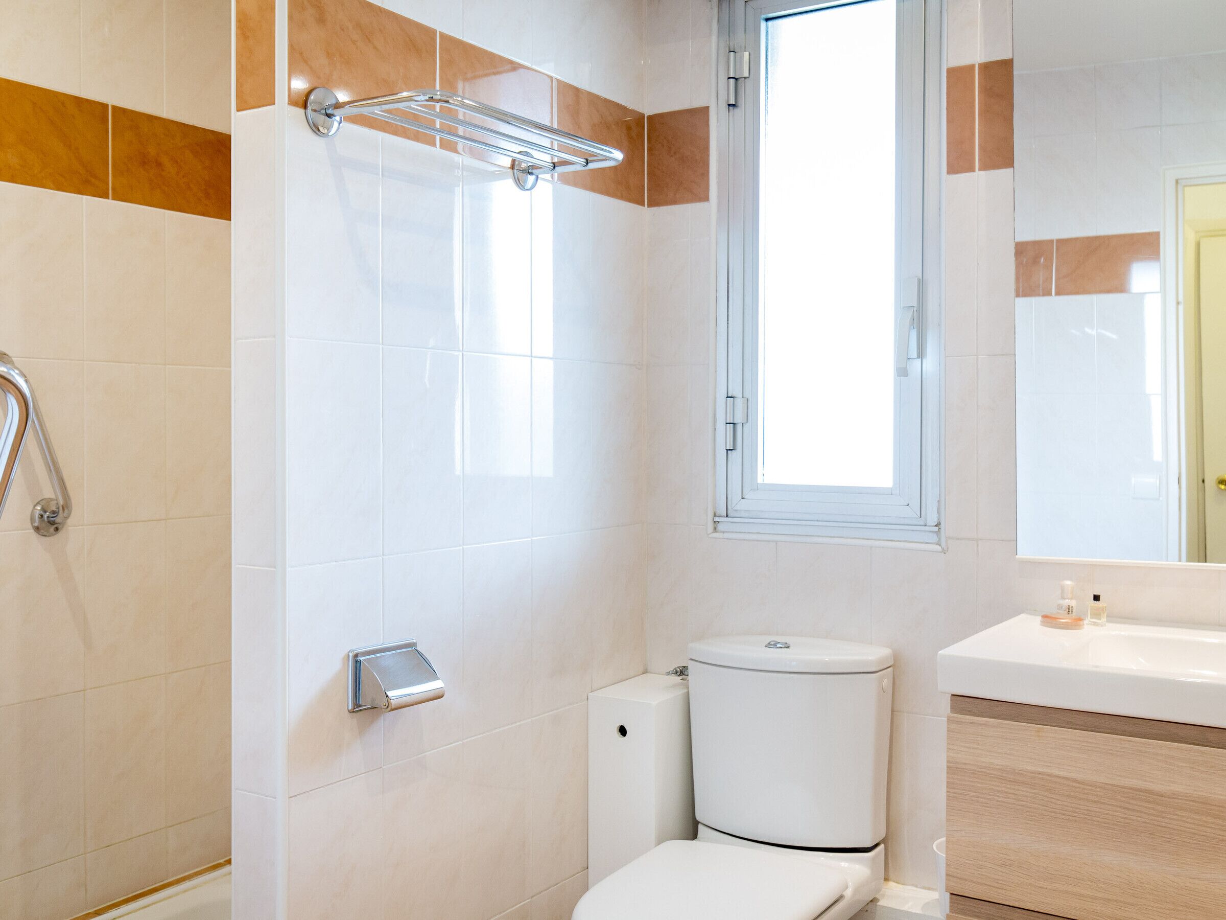 A modern bathroom with a shower, toilet, and sink.