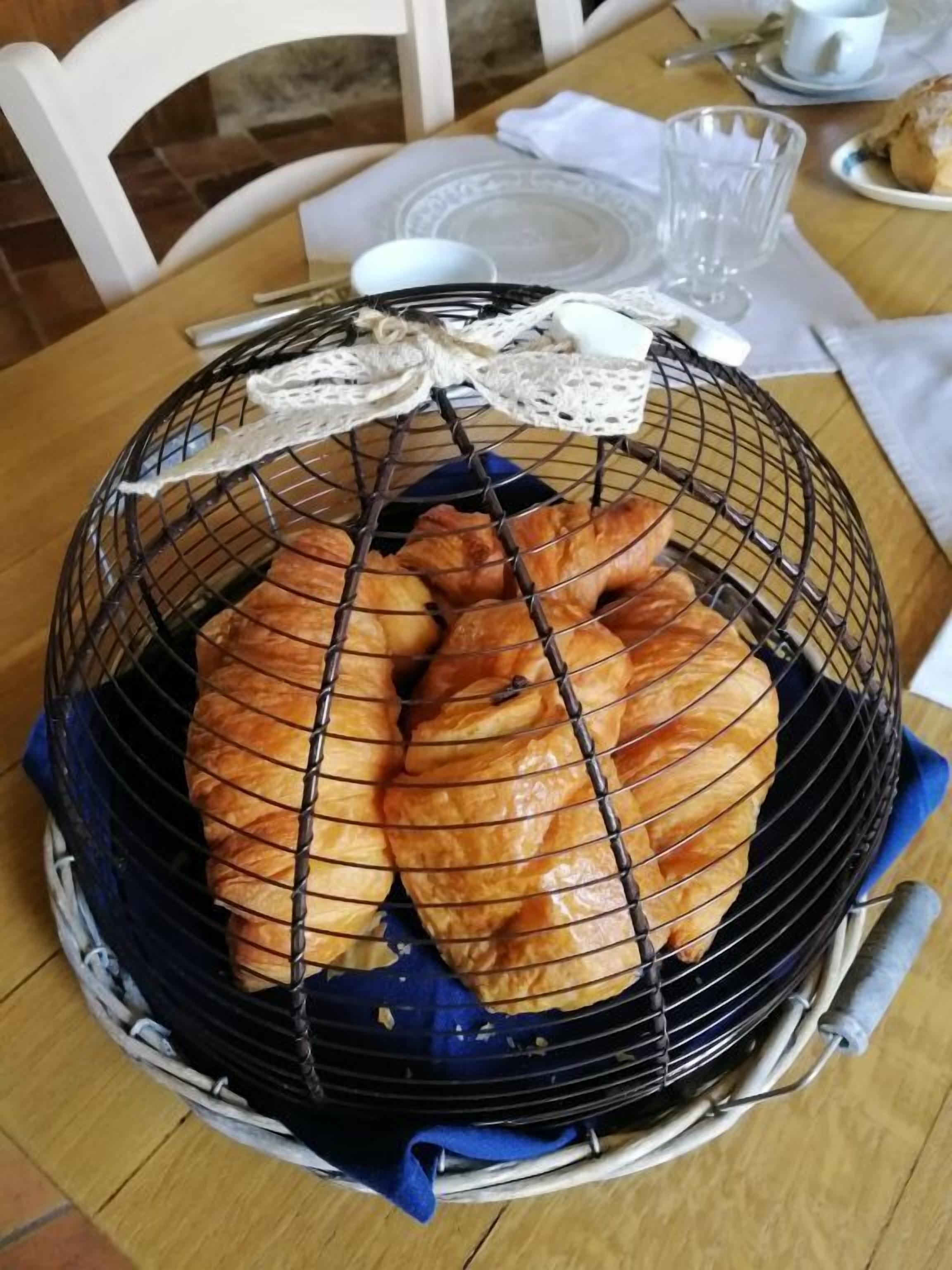 Una cesta de cruasanes sobre una mesa.
