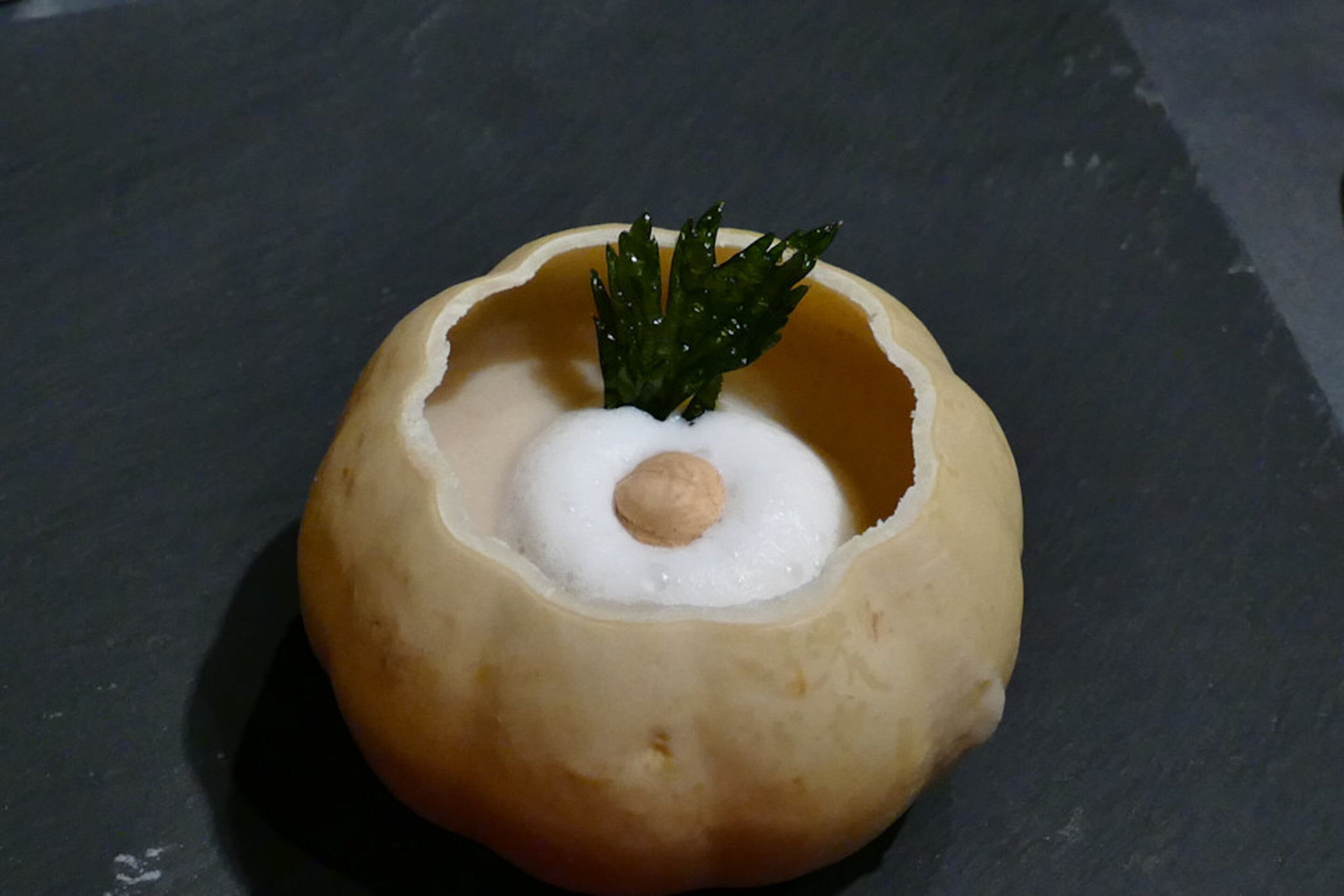 A dessert with a hollow center and a dollop of cream on top.