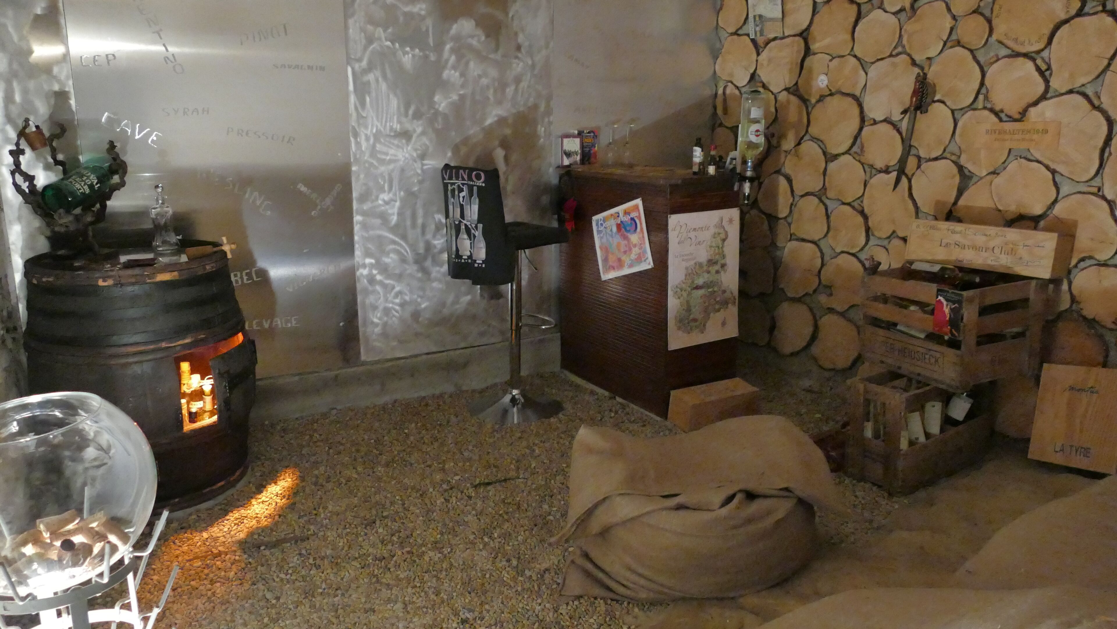 Een rustiek interieur met een stenen muur, houten kisten en vaten.