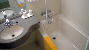 Un baño con lavamanos, espejo y bañera.