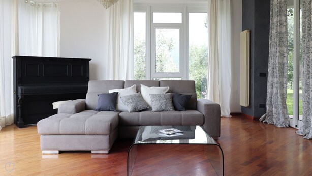 A living room with a sectional sofa, a glass coffee table, and a black entertainment unit. - Italianway - San Bartolomeo 7 (Rapallo)