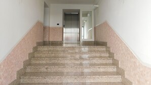 Eine Treppe mit Handlauf, die zu einem Aufzug führt.