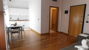 Ein kompakter Wohnraum mit Küchenzeile, Essbereich und Schlafzimmer.