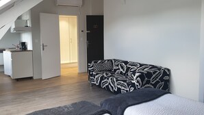 Un appartement moderne doté d’une kitchenette, d’un canapé à motifs et d’un escalier.