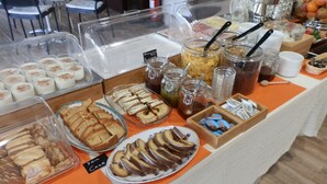 A buffet table with various food items including pastries, cakes, and beverages. - Philoxenia (Kalabaka)