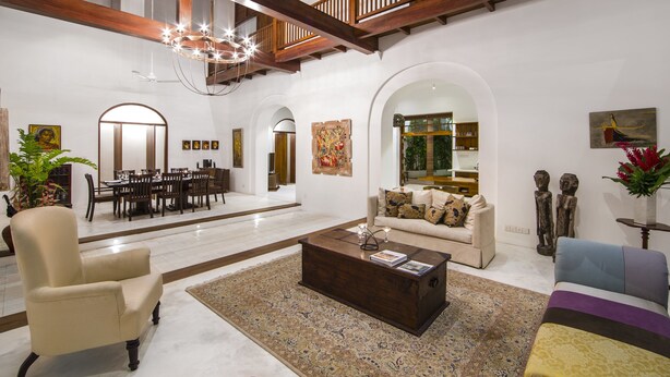 A spacious living area with a high ceiling, a dining area, and a cozy seating area with a sofa and armchairs. - No 05 Middle Street (Galle)
