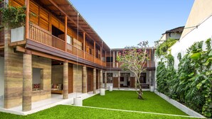 A modern building with a wooden balcony, a well-maintained lawn, and a variety of plants. - No 05 Middle Street (Galle)