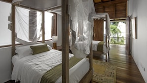 A room with two beds, each with a canopy, a small table, and a view of the outdoors. - No 05 Middle Street (Galle)