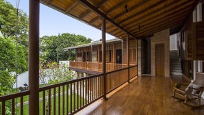 A wooden balcony with a view of a garden and a river. - No 05 Middle Street (Galle)