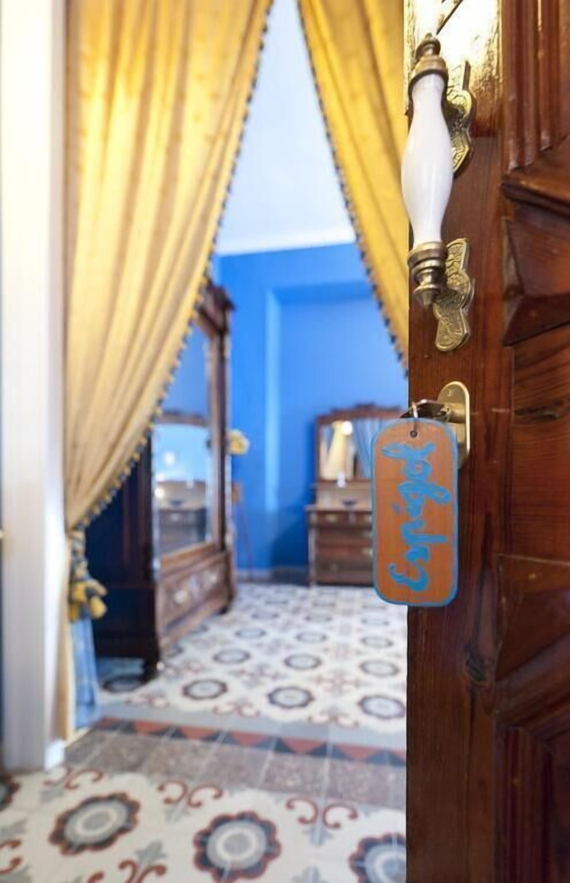 A wooden door with a brass handle and a metal tag hanging on it.