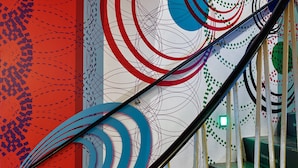A staircase with a handrail, surrounded by a wall with abstract patterns and text. - Das kleine Schwarze (Hamburg)