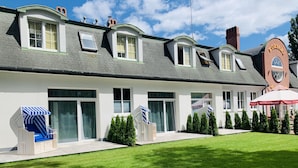 A hotel with a modern design, featuring large windows, a well-maintained lawn, and a prominent sign. - Monte Carlo Boutique Hotel (Swinoujscie)