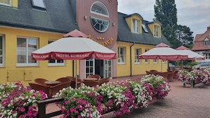 A hotel with outdoor seating and flower beds. - Monte Carlo Boutique Hotel (Swinoujscie)