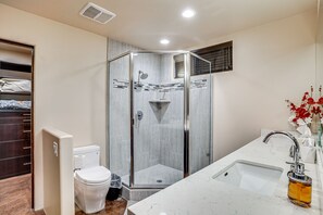 A modern bathroom with a glass-enclosed shower, a toilet, a sink, and a vanity with a mirror. - Mountain-View Patio: Sedona Suite Near Trails (Sedona)