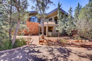 A modern two-story house with a brick facade, large windows, and a balcony. - Mountain-View Patio: Sedona Suite Near Trails (Sedona)
