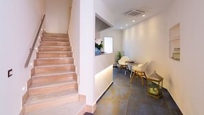 A staircase leading to a reception area with a desk and chairs. - Il Melograno Relais (Vico Equense)