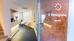 A reception area with a glass door labeled "Il Melograno" and "RELAIS." - Il Melograno Relais (Vico Equense)