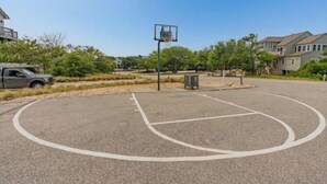 An outdoor basketball court with a hoop, surrounded by trees and residential buildings. - Chapman - 2 Blocks to Beach Access - Resort Amenities (Duck)