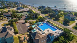 An aerial view of a residential area with a swimming pool, houses, and a waterfront. - Chapman - 2 Blocks to Beach Access - Resort Amenities (Duck)