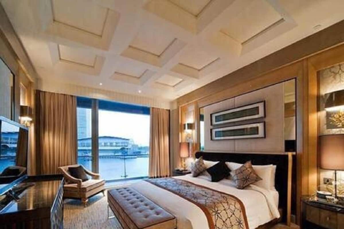 A hotel room with a large bed, a desk, and a view of a body of water.