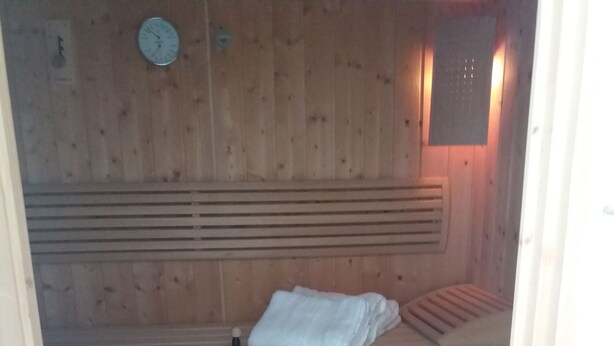 Een sauna met houten banken en een bank op de voorgrond.