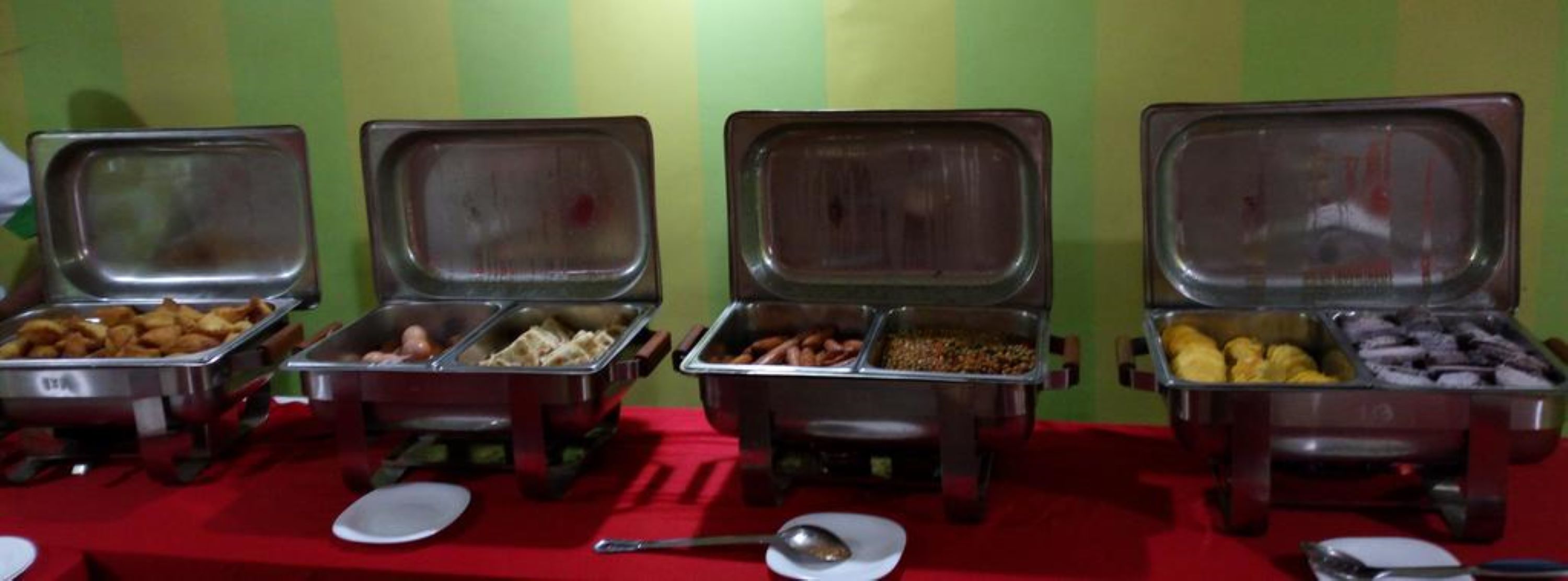 A buffet table with multiple food containers.