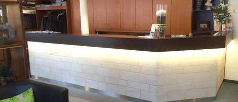 A modern kitchen with wooden cabinets, a black countertop, and a white tiled backsplash.