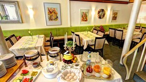 A dining area with multiple tables set for breakfast, featuring a variety of dishes and beverages. - Hotel Kronprinz (Kulmbach)