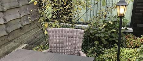 Un patio con una mesa y un farol.