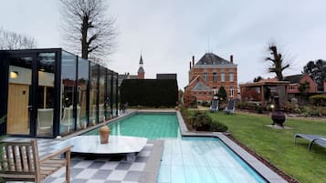 Una piscina al aire libre, sillones reclinables de piscina