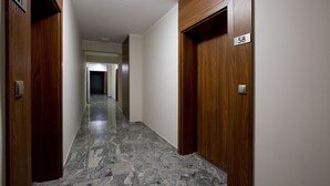 A hallway with wooden doors numbered 51 and 58, leading to rooms. - Super-Apartamenty - Andersia VIP (Poznan)